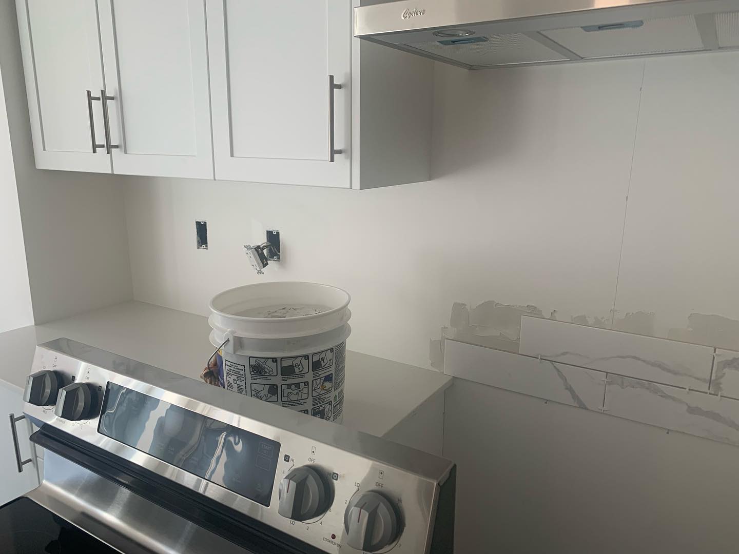 Kitchen backsplash installation in progress behind the range